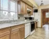 Kitchen featuring tasteful backsplash, light stone countertops, sink, and white appliances