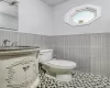 Bathroom featuring tile patterned floors, sink, tile walls, and toilet