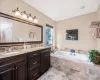 Bathroom featuring vanity and a relaxing tiled tub