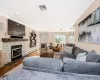 Living room with ornamental molding, baseboard heating, dark wood-type flooring, a fireplace, and a chandelier