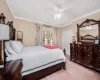 Carpeted bedroom featuring ceiling fan, crown molding, and a closet