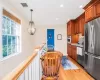 Kitchen with hanging light fixtures, light hardwood / wood-style flooring, stainless steel appliances, and an inviting chandelier