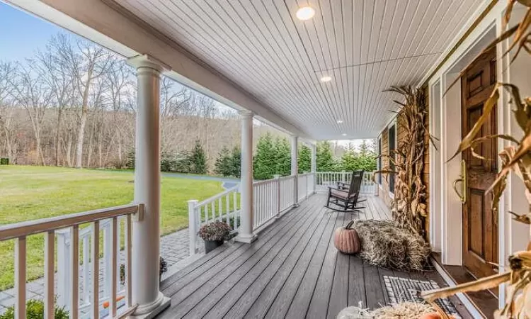 Wooden deck with a porch and a lawn