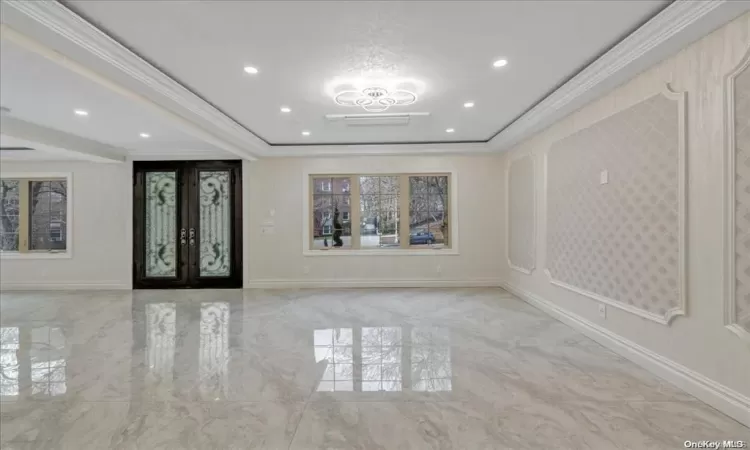 Entrance foyer featuring french doors and crown molding