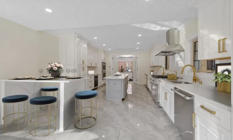 Kitchen with dishwasher, white cabinetry, a kitchen island, and wall chimney exhaust hood (STAGED)