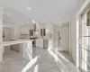 Kitchen with extractor fan, high end appliances, sink, a center island, and white cabinetry (STAGED)