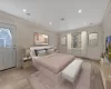 Bedroom featuring light hardwood / wood-style floors, ornamental molding, and multiple windows (STAGED)