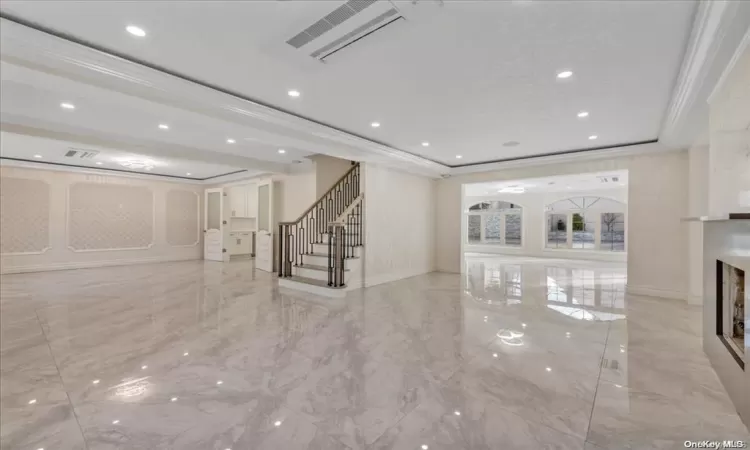 Unfurnished living room featuring crown molding