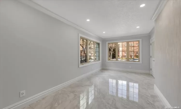 Empty room featuring a textured ceiling and crown molding