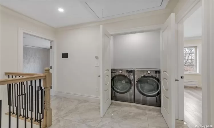 Laundry area with ornamental molding and washing machine and clothes dryer