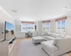 Living room featuring a healthy amount of sunlight, light wood-type flooring, built in desk, and ornamental molding