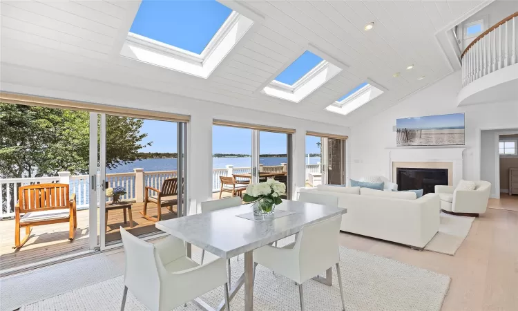 Dining space featuring plenty of natural light, high vaulted ceiling, wood ceiling, and light wood-type flooring