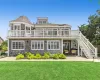 Back of property with a lawn, solar panels, a patio area, and a deck