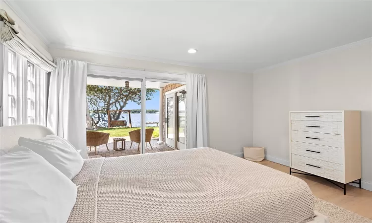 Bedroom featuring access to exterior, ornamental molding, and light hardwood / wood-style flooring