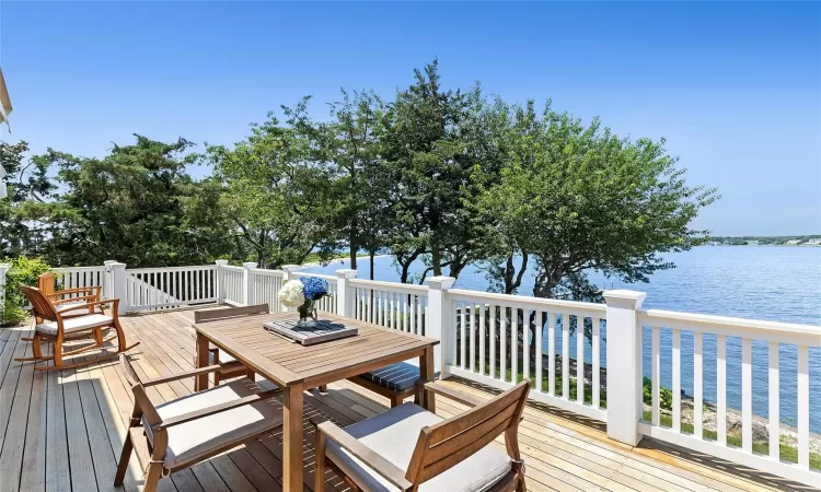 Wooden terrace featuring a water view and a beach view