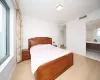 Bedroom featuring multiple windows, light hardwood / wood-style flooring, and ensuite bath