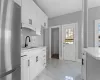 Kitchen with white cabinets, stainless steel fridge, tasteful backsplash, and sink