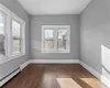 Unfurnished room with a baseboard radiator and dark hardwood / wood-style flooring