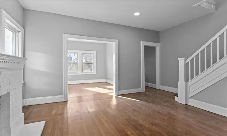 Unfurnished living room featuring wood-type flooring and a fireplace