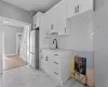 Kitchen featuring sink, white cabinetry, tasteful backsplash, and stainless steel refrigerator