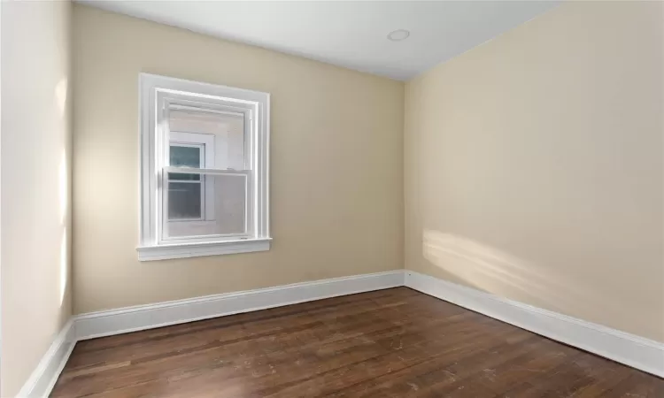 Empty room featuring dark hardwood / wood-style floors