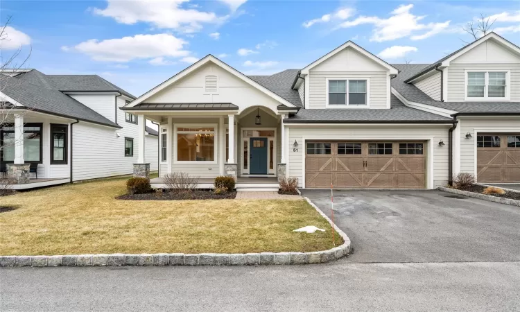 View of front facade featuring a garage and a front lawn