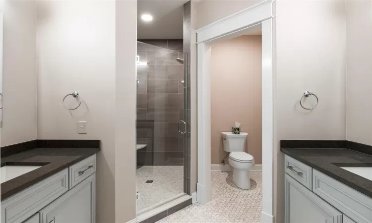 Bathroom with vanity, tile patterned flooring, toilet, and a shower with shower door