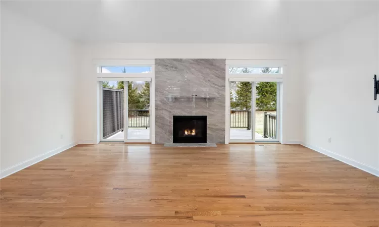 Unfurnished living room with light hardwood / wood-style flooring and a high end fireplace