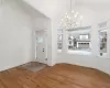 Entryway with a notable chandelier, vaulted ceiling, a wealth of natural light, and wood-type flooring