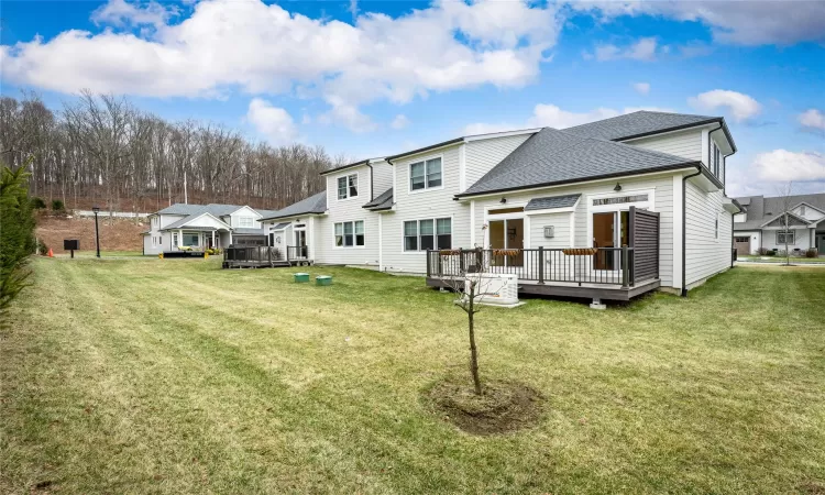 Back of house with a yard and a deck