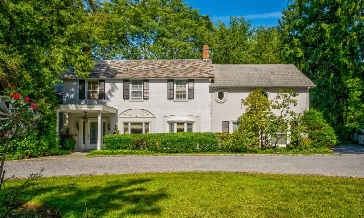 Colonial-style house featuring a front yard