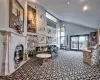 Carpeted living room featuring a premium fireplace and high vaulted ceiling