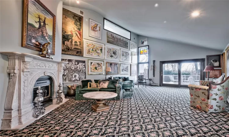 Carpeted living room featuring a premium fireplace and high vaulted ceiling