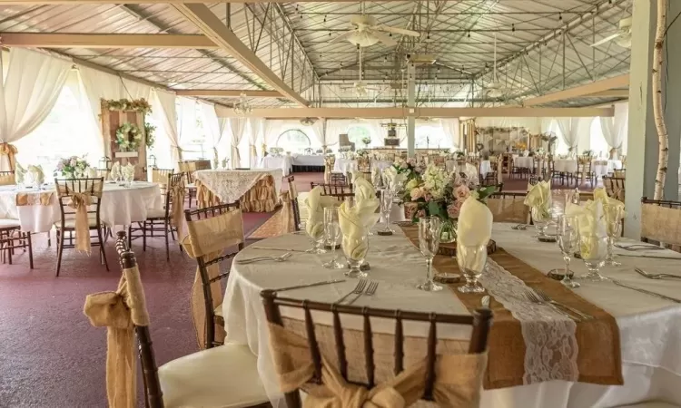 Dining space featuring ceiling fan, carpet floors, and lofted ceiling