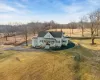 View of front of home featuring a rural view, covered porch, and a front lawn