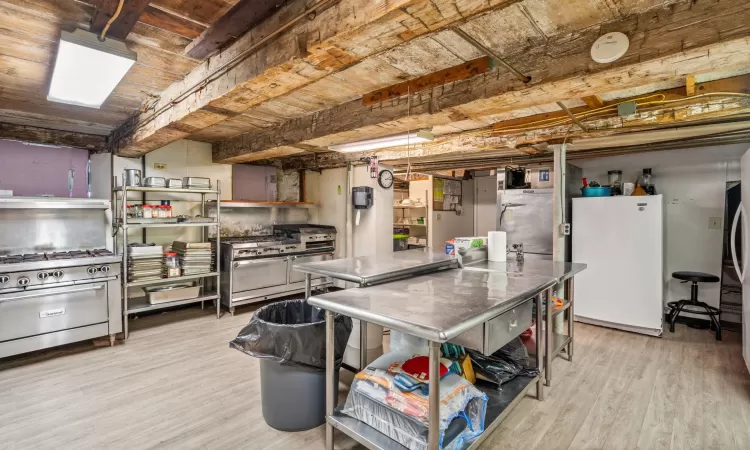 Kitchen with double oven range, high end range, light hardwood / wood-style floors, and white refrigerator