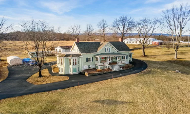 Rear view of house with a lawn and covered porch