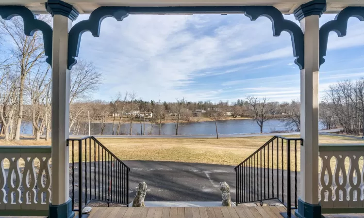 Deck with a water view and a yard