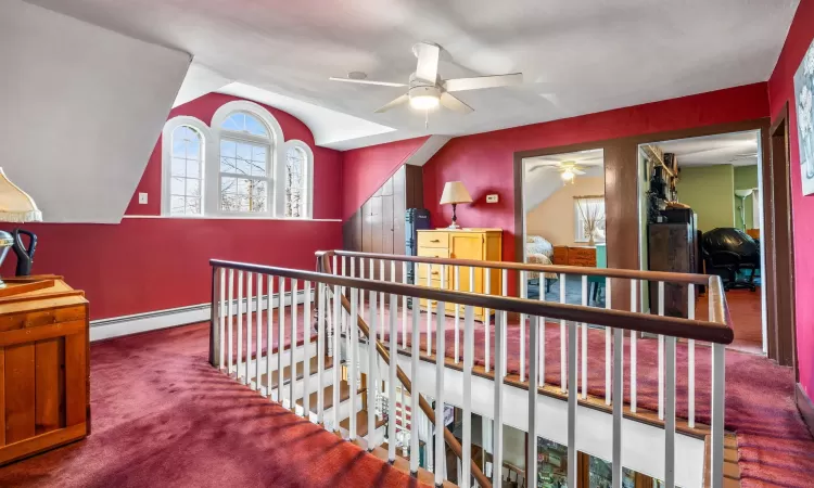 Upstairs landing,ceiling fan, carpet flooring, and lofted ceiling