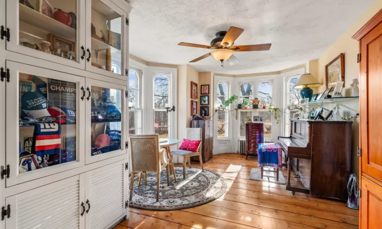 Sitting room featuring a textured ceiling, light hardwood / wood-style flooring, and ceiling fan