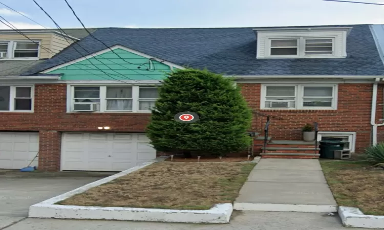 View of front facade with cooling unit and a garage