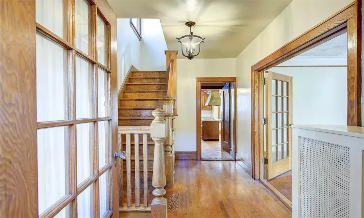 Corridor with french doors and light hardwood / wood-style flooring