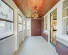 Unfurnished sunroom with an inviting chandelier and wooden ceiling