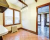 Unfurnished dining area featuring beamed ceiling, radiator heating unit, and tile patterned floors