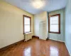 Empty room with radiator heating unit, dark parquet floors, and a textured ceiling