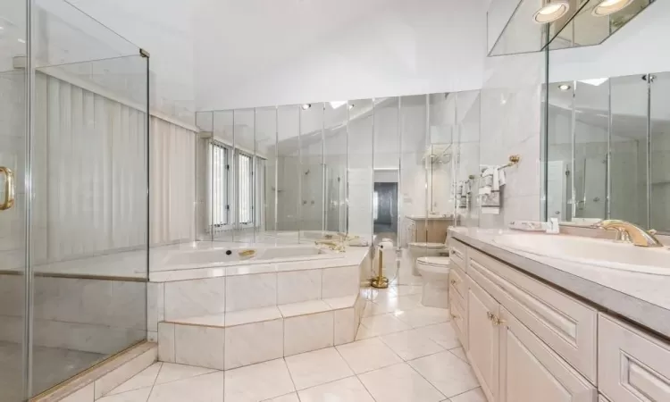 Full bathroom featuring toilet, shower with separate jacuzzi bathtub, high vaulted ceiling, tile floors, and vanity