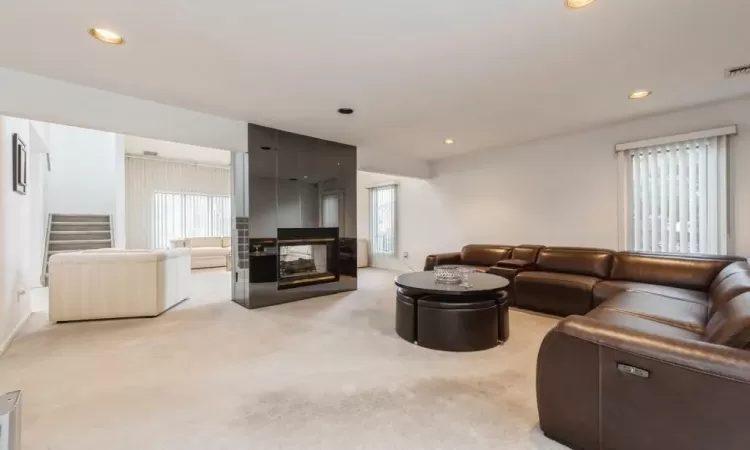 Carpeted casual sitting room featuring fireplace