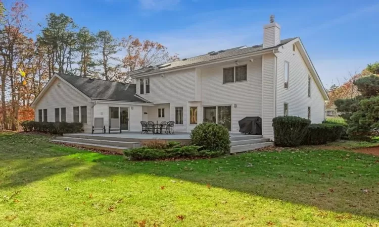 Rear view of property featuring a yard and a trex deck