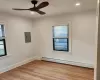 Empty room featuring electric panel, a baseboard heating unit, ceiling fan, and light hardwood / wood-style flooring