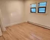 Spare room featuring light wood-type flooring and a baseboard radiator